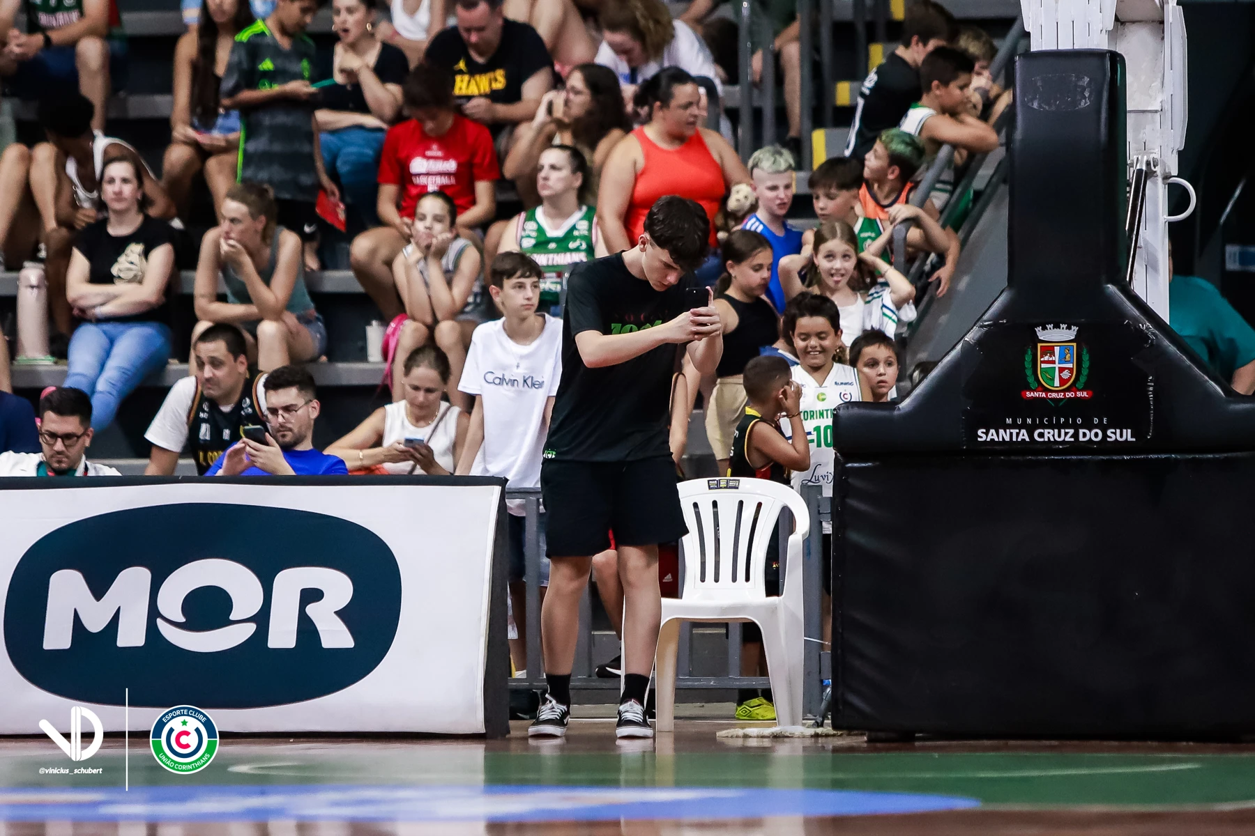 Davi registrando um evento esportivo em uma quadra de basquete